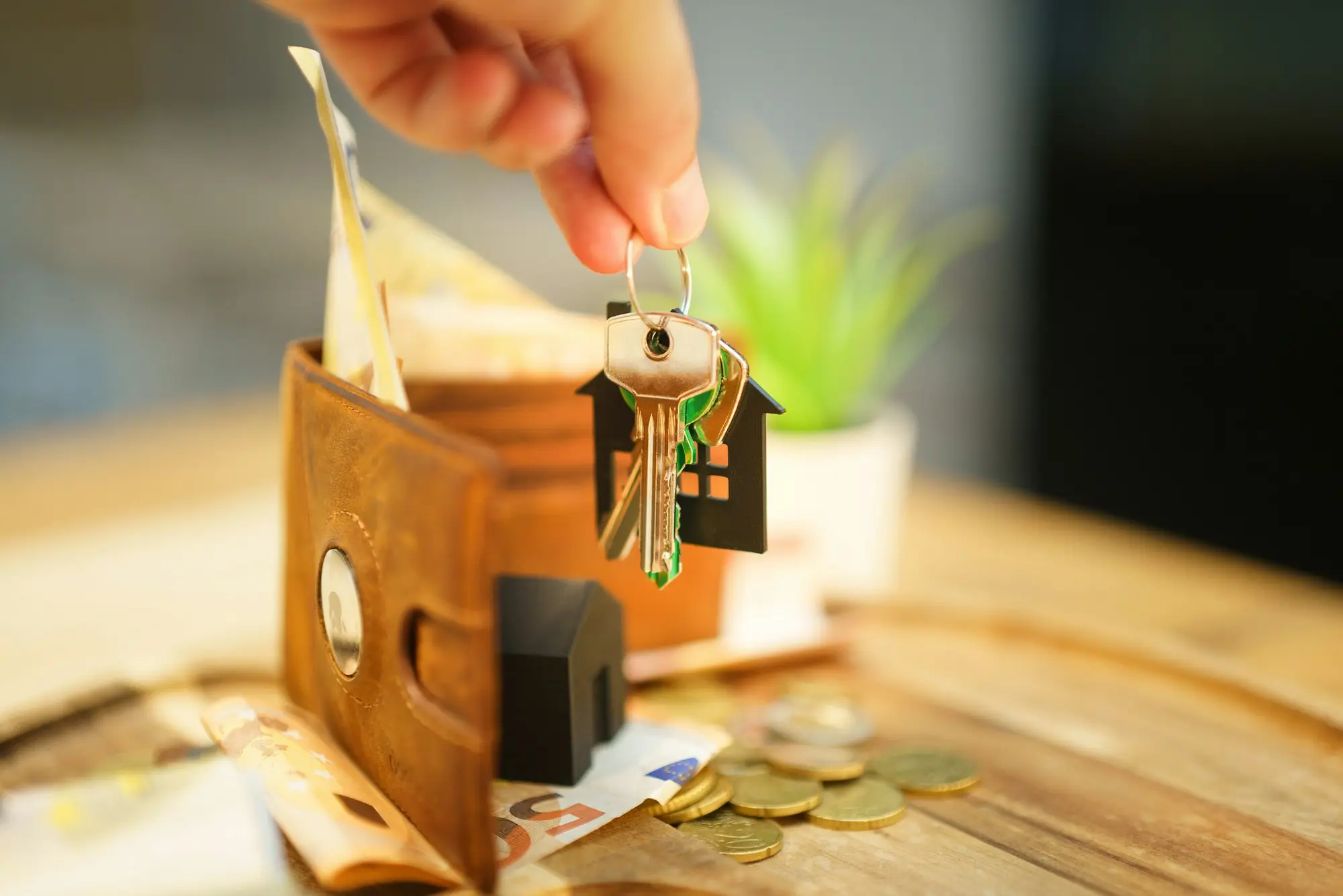 Hand holding keys on a house key ring, representing property offered as security for a business loan